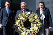 Flanked by U.S. Rep. Rob Menendez, left, and U.S. Agency for International Development (USAID) Assistant Administrator Erin McKee, right, U.S. Sen. Bob Menendez carries a wreath to the waterfront walkway during a commemoration of the one-year anniversary of Russia's invasion of Ukraine at Harborside Plaza 3 in Jersey City on Monday, Feb. 13, 2023. (Reena Rose Sibayan | The Jersey Journal)