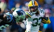 Green Bay Packers running back Aaron Jones runs past Carolina Panthers cornerback Donte Jackson during the first half of an NFL football game Sunday, Dec. 24, 2023, in Charlotte, N.C.